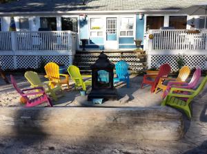a group of colorful chairs and tables in front of a house at Wu Wu's Cabins in Wasaga Beach