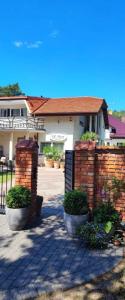 a brick fence in front of a house at Domki i Apartamenty El-Piero in Pobierowo