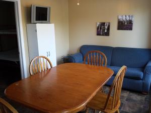 a living room with a wooden table and a blue couch at Wu Wu's Cabins in Wasaga Beach