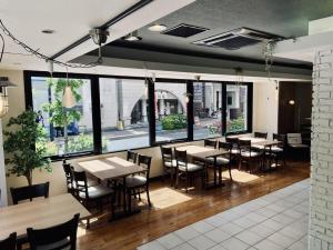 a restaurant with tables and chairs and large windows at Court Hotel Shin-Yokohama in Yokohama