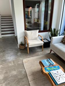 a living room with a white chair and a coffee table at Essência do Sol Pousada in Florianópolis