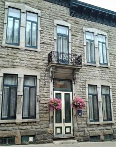 un edificio de piedra con flores delante en B&B de la Fontaine en Quebec