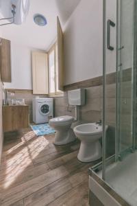 ein Badezimmer mit 2 WCs und einem Waschbecken in der Unterkunft Ad un passo dal molo in Porto Torres