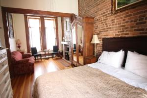 a bedroom with a bed and a brick wall at B&B de la Fontaine in Quebec City