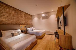 a hotel room with two beds and a television at HOTEL CASA ARANZAZU SAN LUIS POTOSI in San Luis Potosí