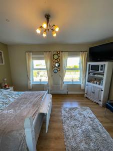 a bedroom with a large bed and two windows at Valley View 1 (Tourist board registered) in Tamnyrankin