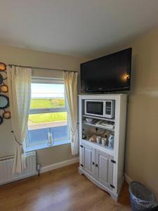 a living room with a microwave and a window at Valley View 1 (Tourist board registered) in Tamnyrankin