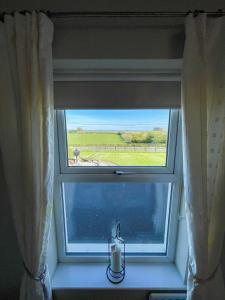 una ventana con una vela en el alféizar de la ventana en Valley View 1 (Tourist board registered), en Tamnyrankin