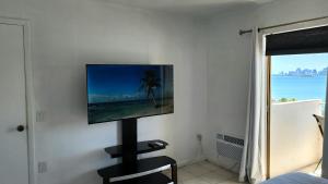 a flat screen tv on a wall in a room at Bayfront Apartment Breathtaking Views- one bedroom w balcony- living room -Free Parking in Miami Beach
