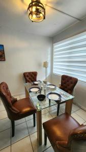 a dining room with a glass table and chairs at Bayfront Apartment Breathtaking Views- one bedroom w balcony- living room -Free Parking in Miami Beach