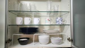 a cabinet filled with plates and cups and dishes at Bayfront Apartment Breathtaking Views- one bedroom w balcony- living room -Free Parking in Miami Beach