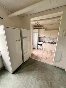 una cocina vacía con electrodomésticos blancos en una habitación en Naffentorps Hotel en Bunkeflostrand