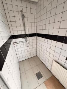 y baño con ducha y azulejos blancos y negros. en Naffentorps Hotel en Bunkeflostrand