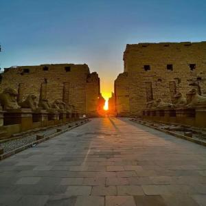 a view of the sun setting behind a building at Kiara Nile Cruise every Saturday, Monday and Thursday from Luxor in Jazīrat al ‘Awwāmīyah