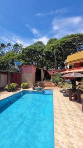 uma grande piscina azul em frente a uma casa em Villa Blue Point - Chácara com piscina e 4 quartos em Vila Velha