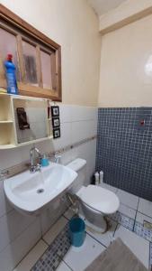 La salle de bains est pourvue d'un lavabo et de toilettes. dans l'établissement Villa Blue Point - Chácara com piscina e 4 quartos, à Vila Velha
