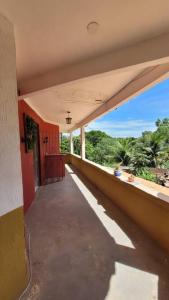 une terrasse couverte vide d'un bâtiment avec vue sur les arbres dans l'établissement Villa Blue Point - Chácara com piscina e 4 quartos, à Vila Velha