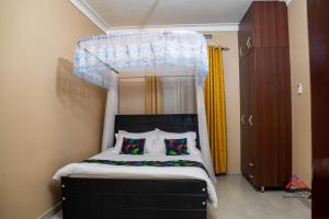 a bedroom with a canopy bed with two pillows at Kica Apartment with Airconditioned bedrooms in Lira, Uganda in Lira