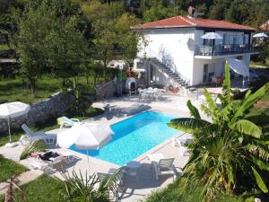 een villa met een zwembad en een huis bij Apartments Ema in Lovran