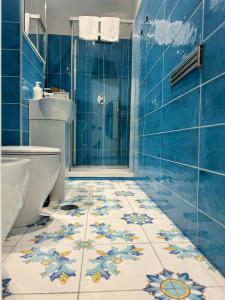 a blue tiled bathroom with a toilet and a shower at Panoramic Flat Amalfi Coast - Sea View 1 in Vietri sul Mare