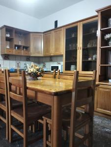 una cucina con tavolo in legno e armadi in legno di Casa Vacanze La Pineta a Taviano