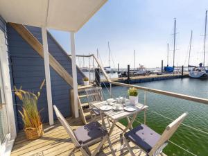 a table and chairs on a deck with a marina at Houseboat Lasse for family in Heiligenhafen