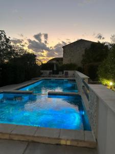 a swimming pool with blue water in a backyard at Le Mas de Ponge in Nîmes