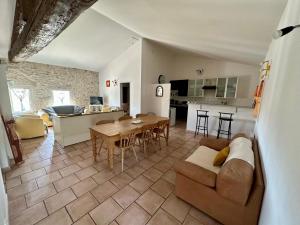a living room and kitchen with a couch and a table at Le Mas de Ponge in Nîmes