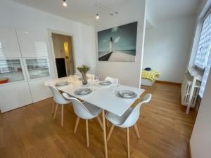 Un comedor blanco con una mesa y sillas blancas. en La Pause Messine - 3 Chambres, en Metz