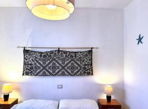 1 dormitorio con almohada blanca y negra y 2 lámparas en Stunning apartment in beautiful Villa Florence, 150 mt from the beach, gated 5 mt from the sea, en Solanas
