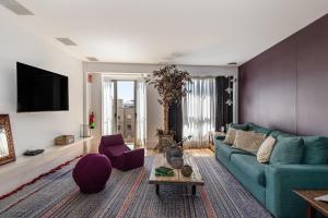 a living room with a blue couch and a tv at BNBHolder Luxury Triplex CHAMBERI in Madrid