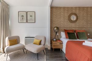 マドリードにあるBNBHolder Luxury Triplex CHAMBERIのベッドルーム1室(ベッド1台、椅子2脚付)