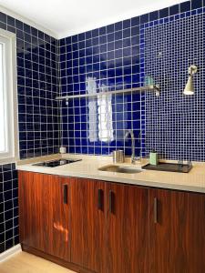 - une cuisine carrelée de bleu avec deux lavabos et un miroir dans l'établissement Petek Pansiyon Fenerbahce Kadikoy, à Istanbul