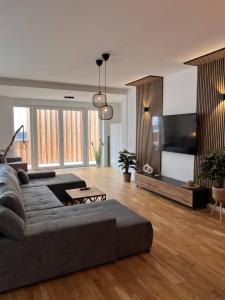 a living room with a couch and a television at KeyHosting Apartment Zentral Parkplatz in Aschaffenburg