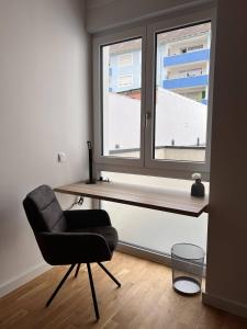 a desk and a chair in a room with a window at KeyHosting Apartment Zentral Parkplatz in Aschaffenburg