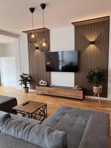 a living room with a couch and a flat screen tv at KeyHosting Apartment Zentral Parkplatz in Aschaffenburg