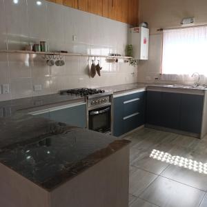 uma cozinha com armários azuis e um forno com placa de fogão em El sueño del flaco em San Martín de los Andes
