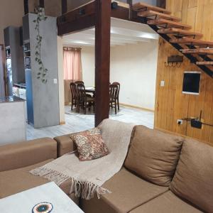 uma sala de estar com um sofá e uma sala de jantar em El sueño del flaco em San Martín de los Andes