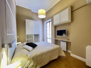 ein Schlafzimmer mit einem Bett und einem TV an der Wand in der Unterkunft Casa Gramsci Anzio Centro in Anzio
