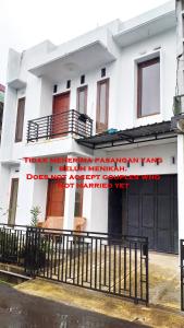 a white building with a sign on it at Ganendra Syari'ah Guesthouse in Dieng