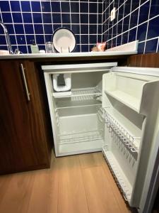 an empty refrigerator with its door open in a kitchen at Petek Pansiyon Fenerbahce Kadikoy in Istanbul