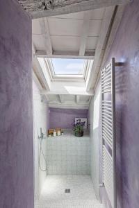 a bathroom with purple walls and a skylight at Il Nido in Buonconvento