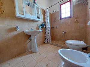 bagno con lavandino, servizi igienici e finestra di Casa Vacanze La Pineta a Taviano
