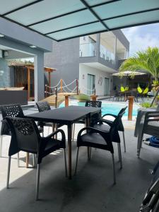 un patio con tavolo, sedie e piscina di Cafofo new beach a Salinópolis