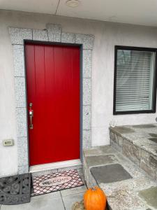 a red garage door with a pumpkin in front of it at One bedroom with modern kitchen, balcony with water view in Greenwich