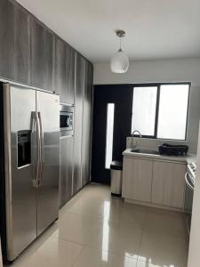 uma cozinha com um frigorífico de aço inoxidável e um lavatório em Casa 112 Residencial Framboyanes em Santa Cruz Xoxocotlán