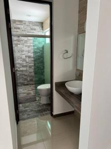 uma casa de banho com um WC, um lavatório e um espelho. em Casa 112 Residencial Framboyanes em Santa Cruz Xoxocotlán