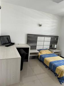 um quarto com uma cama e uma secretária com um computador em Casa 112 Residencial Framboyanes em Santa Cruz Xoxocotlán