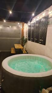 a large bath tub in a room with a table at Cabin of Light - Hot Tub, Sauna, Massage Chair, BBQ, Games, Beach in Monkwearmouth