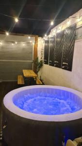 uma grande banheira azul num quarto com uma mesa em Cabin of Light - Hot Tub, Sauna, Massage Chair, BBQ, Games, Beach em Monkwearmouth